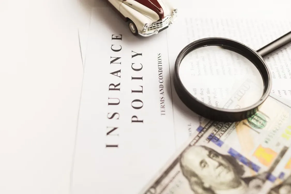 Magnifying glass and an insurance policy document.