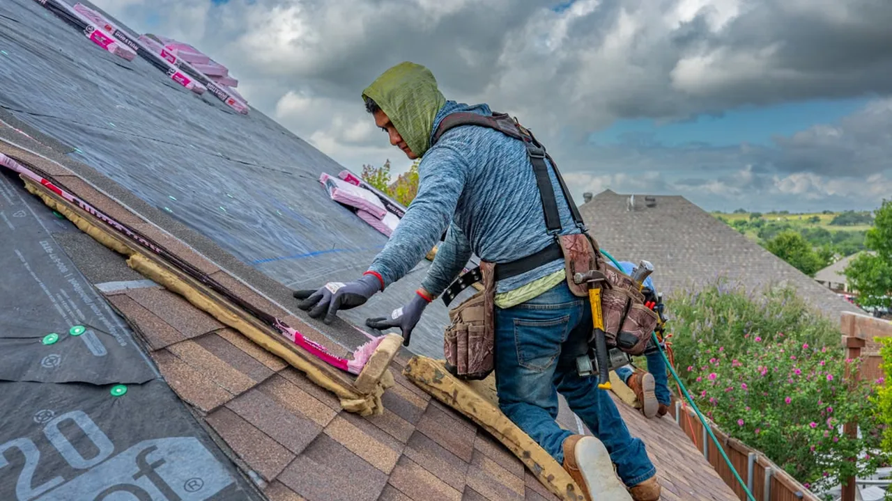 Roofers installing shingles on a sunny day