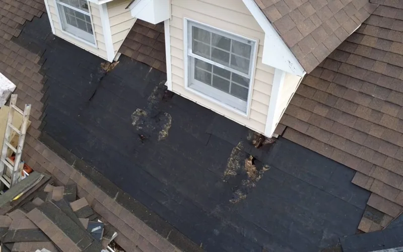 Roof repair in progress with the old shingles stripped back